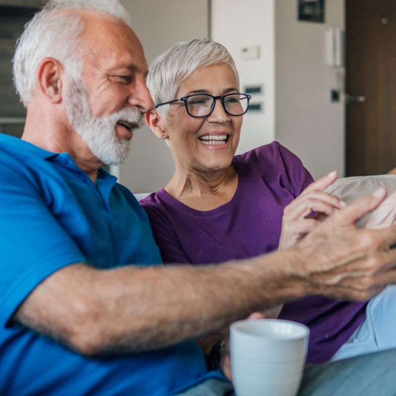 Happy senior couple relaxing at home and smiling together — The Neat Nest comfort living inspiration.