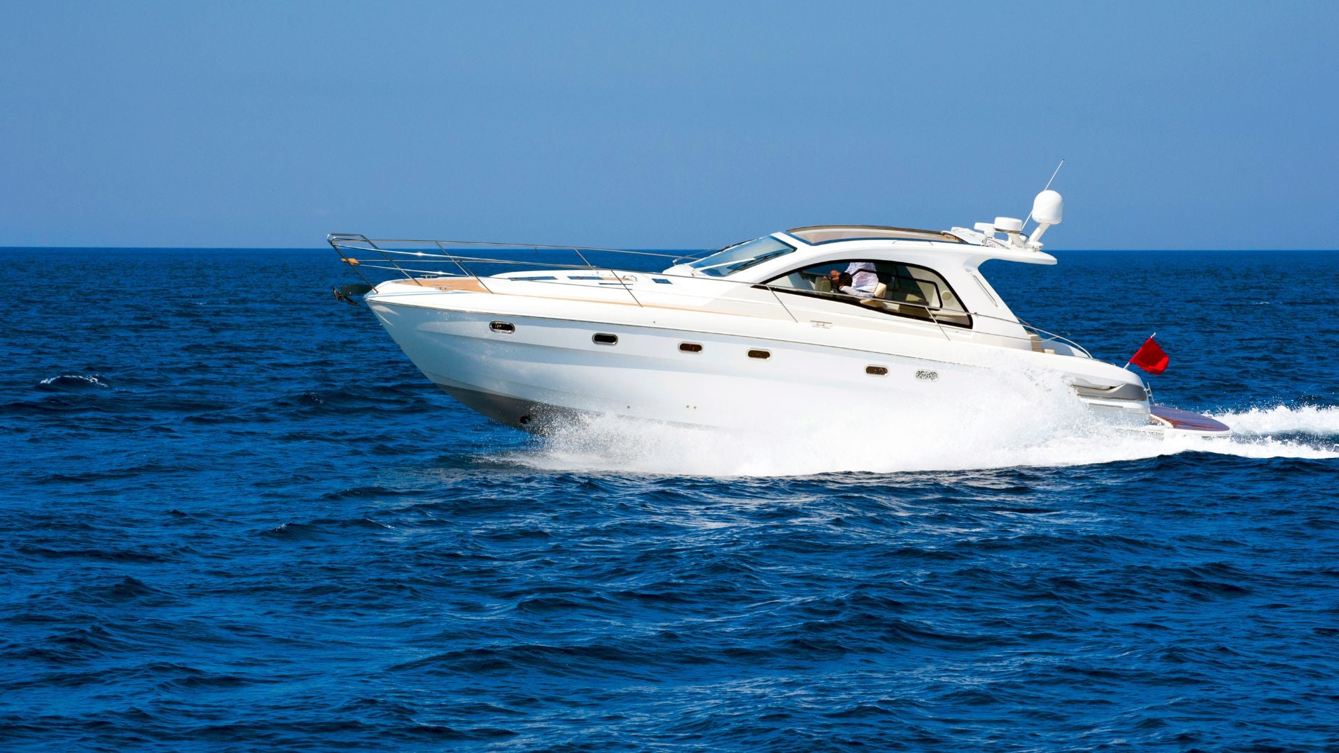 Luxury yacht cruising across open blue waters, showcasing speed, elegance, and freedom at sea.